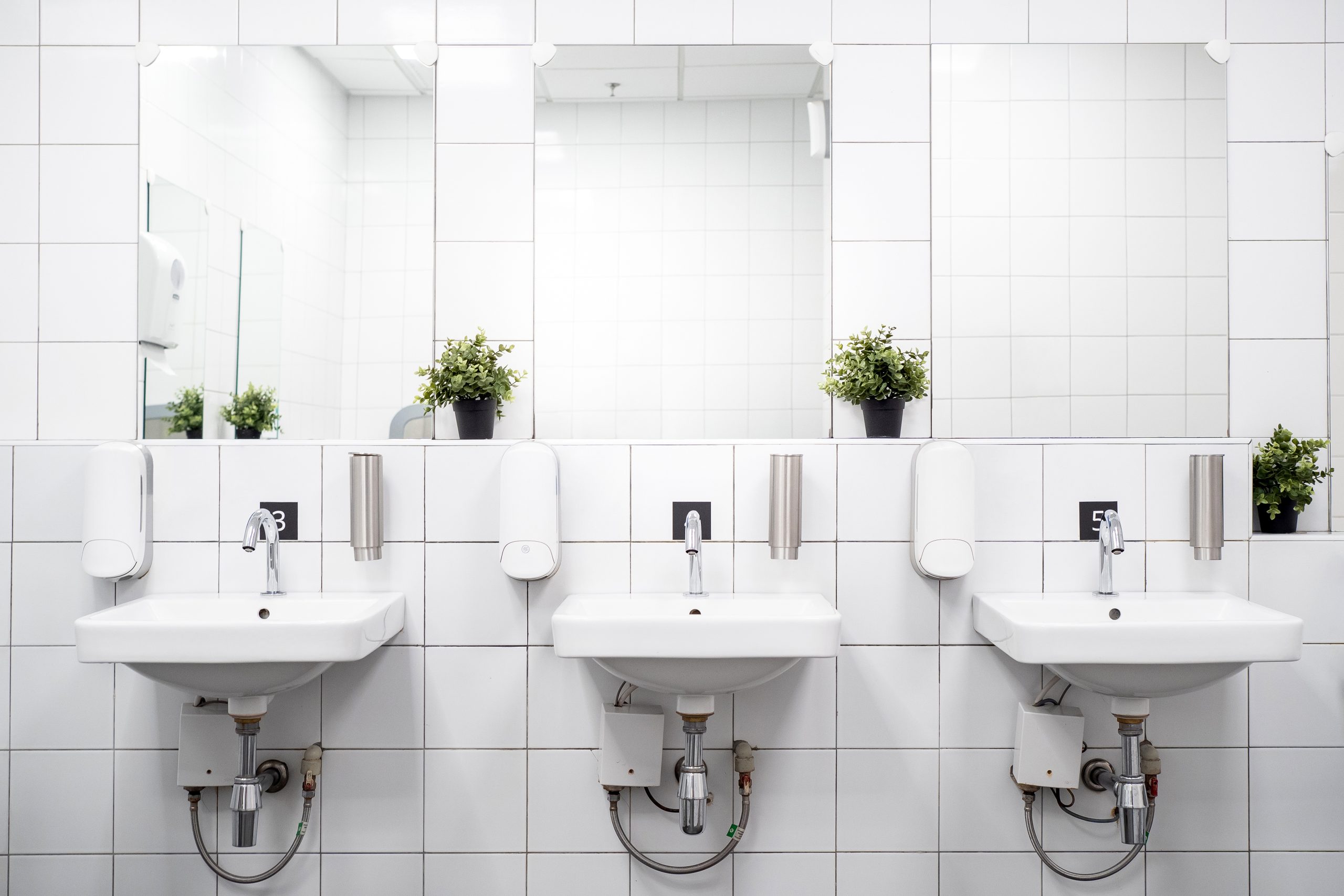 A ceramic bathroom floor with a white grout. The floor is smooth and has a glossy finish. It is a modern and stylish look that is perfect for any bathroom.