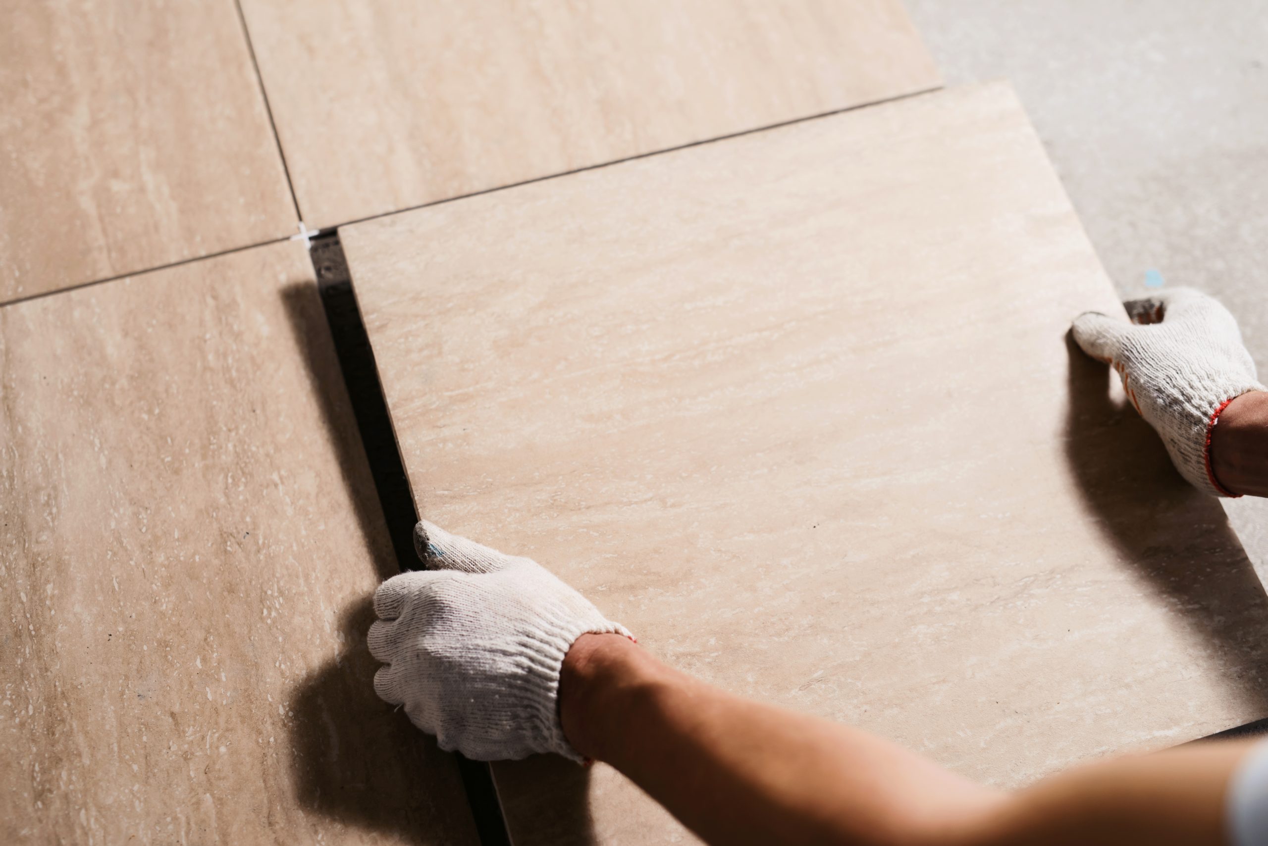 A ceramic bathroom floor with a white grout. The floor is smooth and has a glossy finish. It is a modern and stylish look that is perfect for any bathroom.