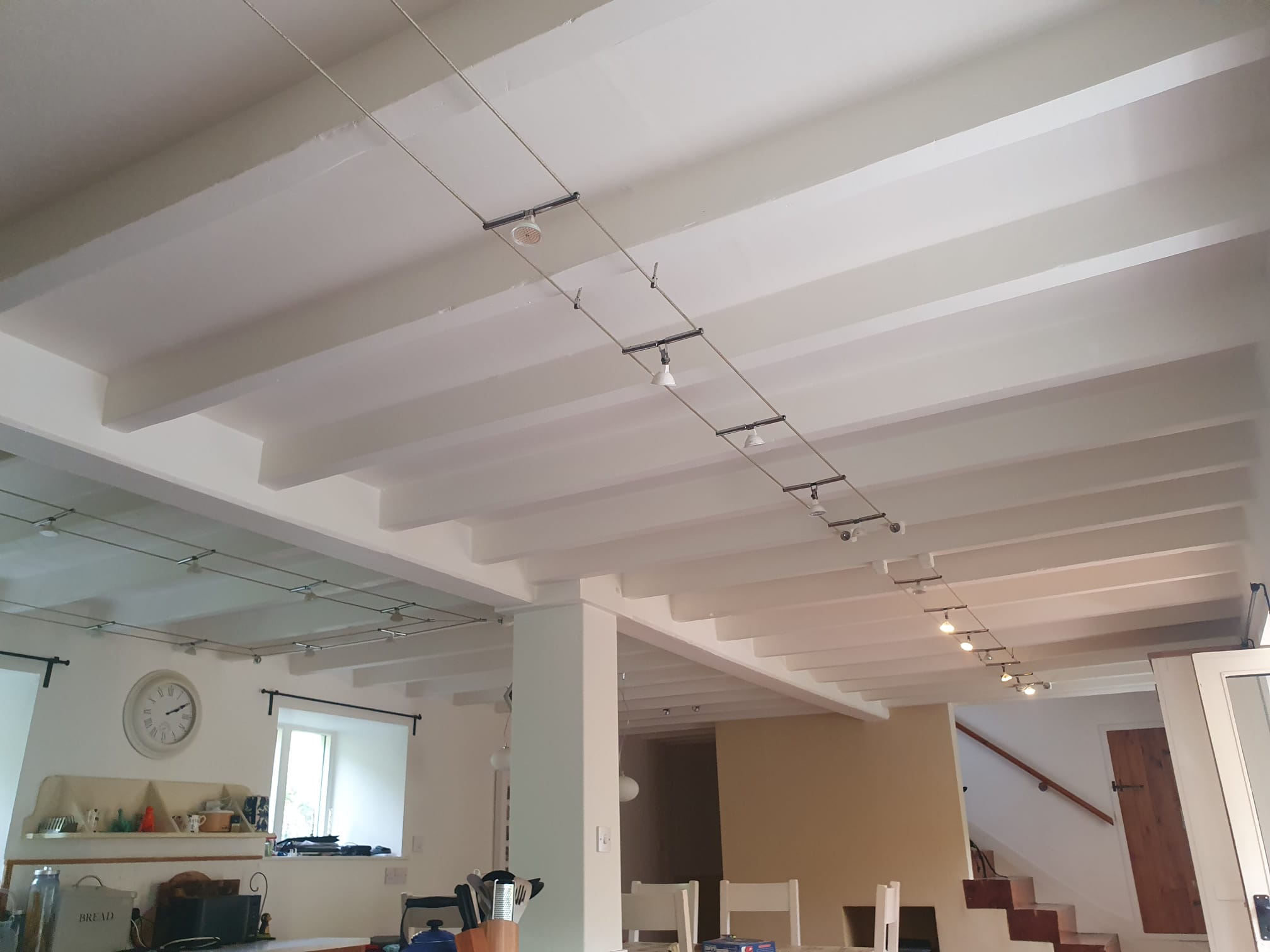 Painted ceiling beams around the existing kitchen track lighting